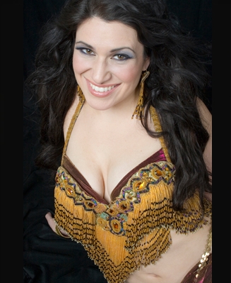 Eden Fieldstone headshot in traditional belly dance bra and hip scarves